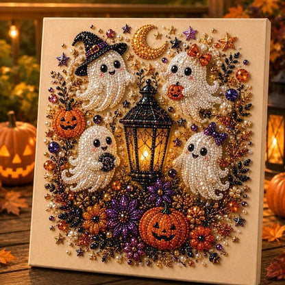 A square Halloween-themed beaded wall art piece featuring four white ghosts, two orange pumpkins, a black witch hat, a glowing lantern, stars, and purple flowers on a cream background, displayed in a warm, festive setting with blurred pumpkins and lights.